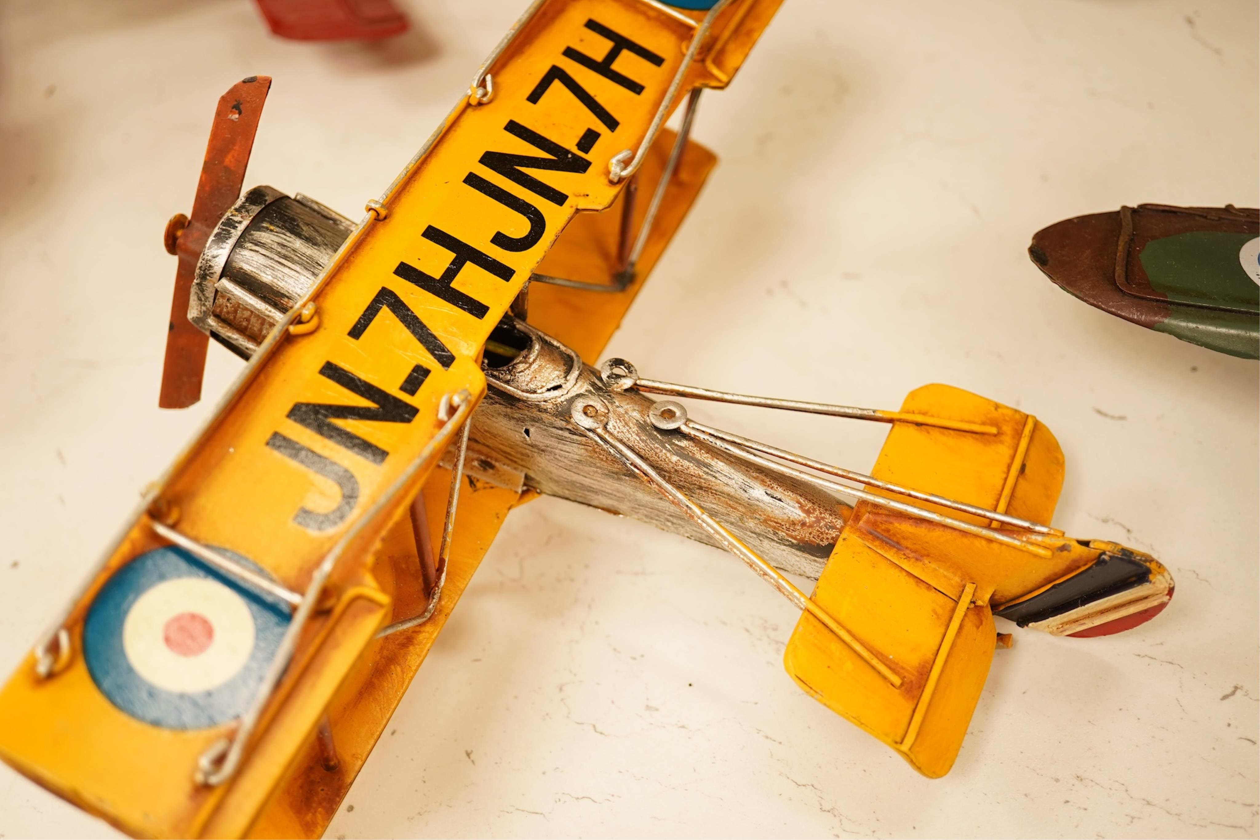 Five decorative metal models of military aircraft, including two Supermarine Spitfires, two First World War, British bi-planes, a German Albatros D.III bi-plane, and a wooden model of RMS Queen Mary, hull 77cm long
